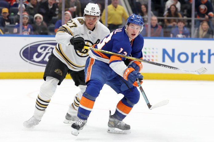 Boston Bruins defenseman Hampus Lindholm (27) skates against New York Islanders center Mathew Barzal (13)