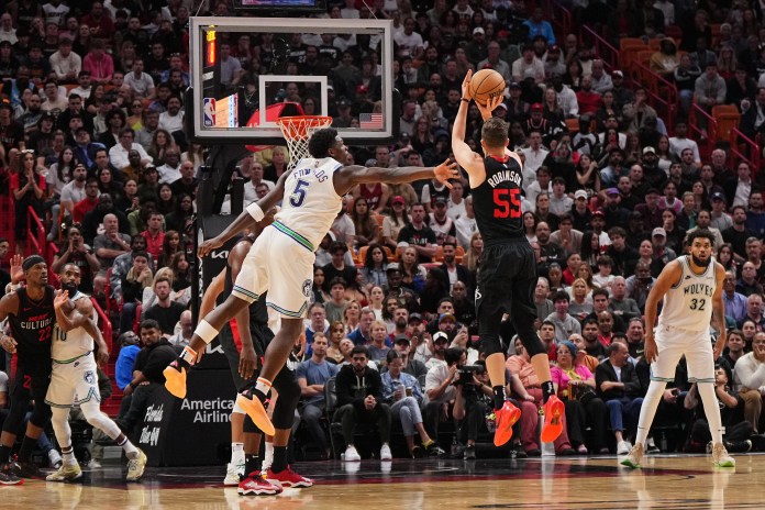 Miami Heat forward Duncan Robinson (55) attempts a three point shot against Minnesota Timberwolves guard Anthony Edwards (5)