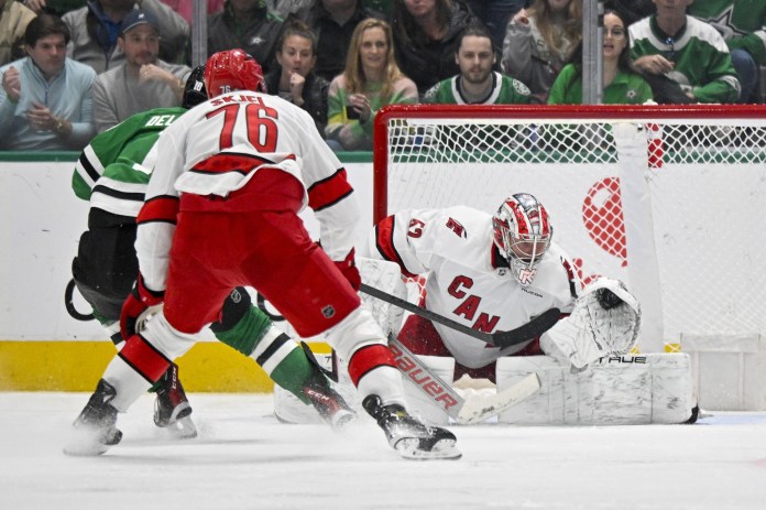 Carolina Hurricanes goaltender Pyotr Kochetkov (52) makes a glove save on a shot by Dallas Stars center Ty Dellandrea (10