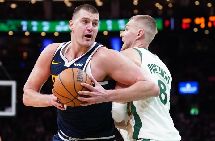 Denver Nuggets center Nikola Jokic works the ball around Boston Celtics center Kristaps Porzingis in the second quarter at TD Garden.