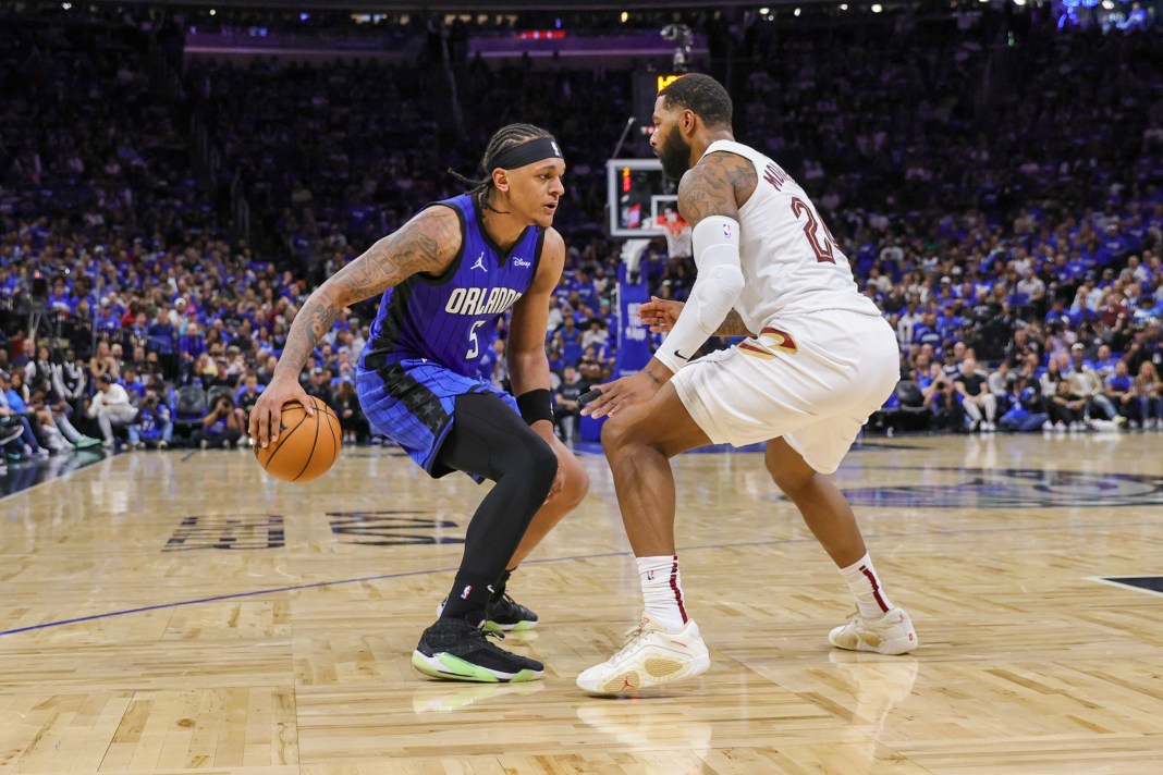 Orlando Magic forward Paolo Banchero handles the ball in front of Cleveland Cavaliers forward Marcus Morris Sr. the 2024 NBA playoffs.