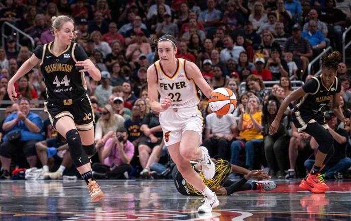 Indiana Fever guard Caitlin Clark rushes up the court against Washington Mystics guard Karlie Samuelson.
