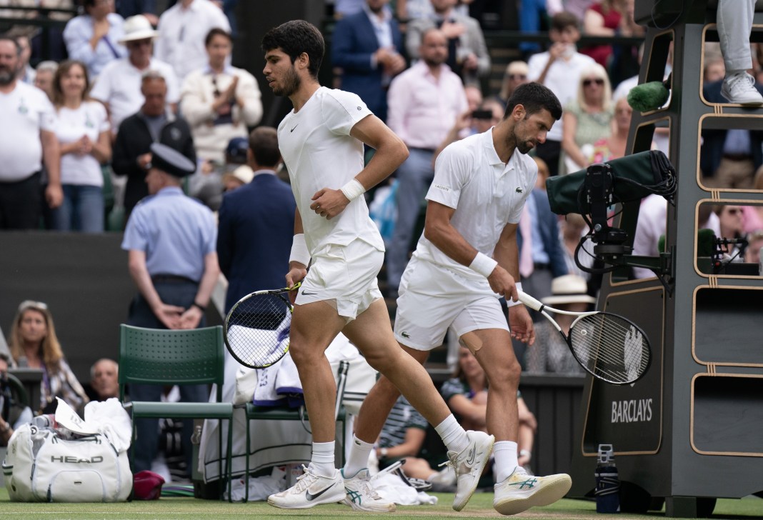 Carlos Alcaraz and Novak Djokovic change ends in their meeting in the 2023 Wimbledon final.