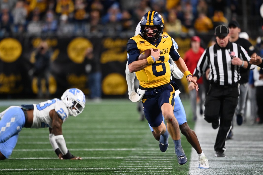 West Virginia quarterback Garrett Greene runs by a North Carolina player in the Duke's Mayo Bowl.