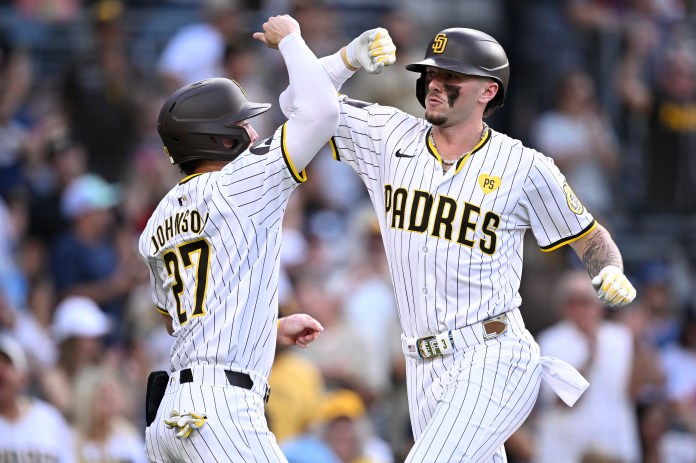 San Diego Padres center fielder Jackson Merrill (3) celebrates with Bryce Johnson (27) after hitting a two-run home run during the eighth inning of the game against the Minnesota Twins at Petco Park in San Diego, California, on August 21, 2024.