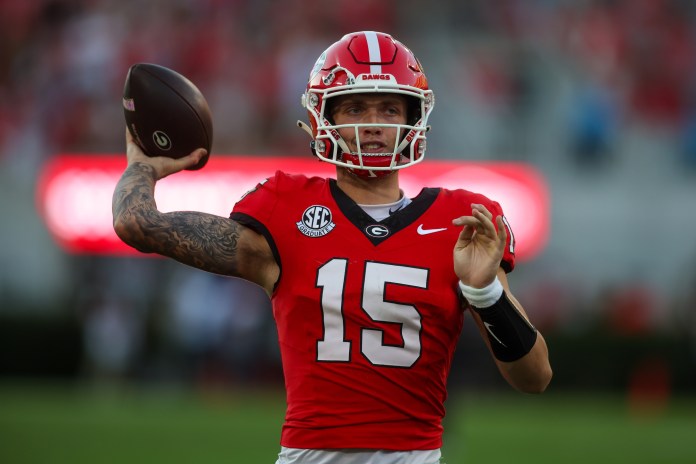 Georgia Bulldogs quarterback Carson Beck (15) warms up against the Mississippi State Bulldogs in the third quarter at Sanford Stadium