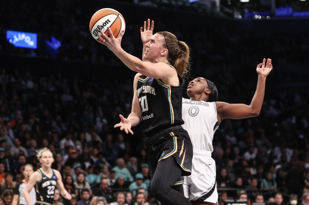 New York Liberty guard Sabrina Ionescu (20) drives past Las Vegas Aces guard Jackie Young (0) in the third quarter during game two of the 2024 WNBA Semi-finals at Barclays Center