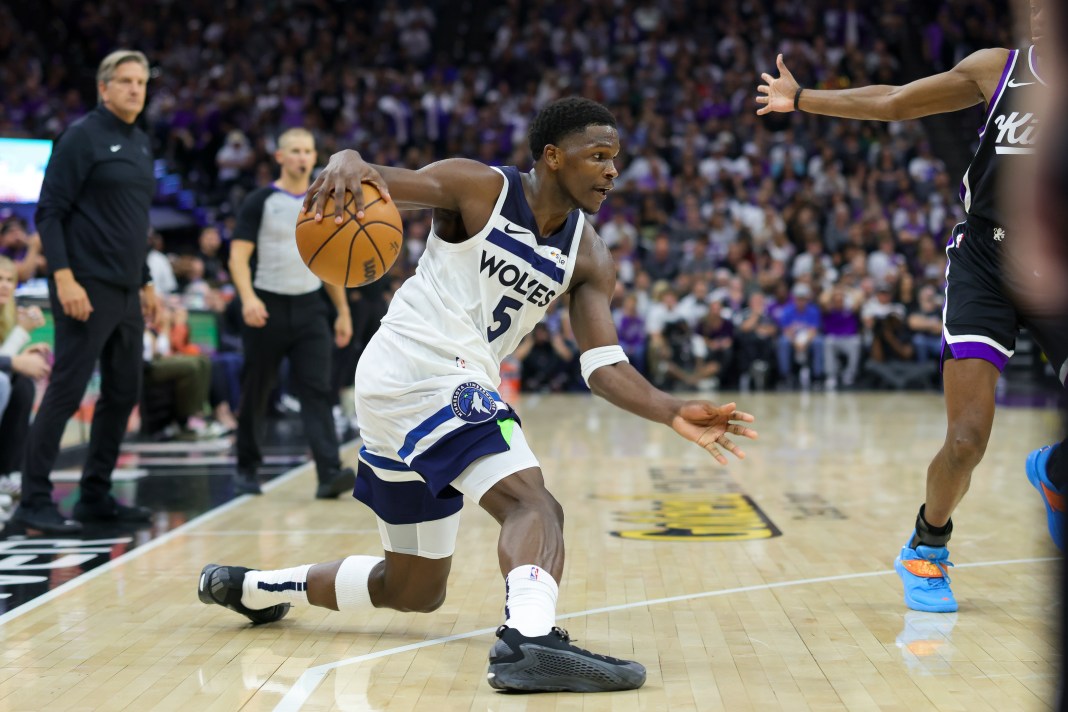 Minnesota Timberwolves guard Anthony Edwards dribbles the ball against Sacramento Kings guard De'Aaron Fox.