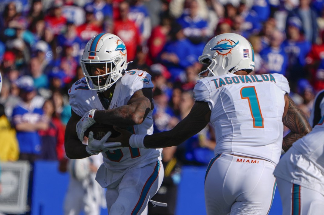 Dolphins quarterback Tua Tagovailoa hands the ball to Raheem Mostert in a meeting with the Bills in the 2024 NFL season.