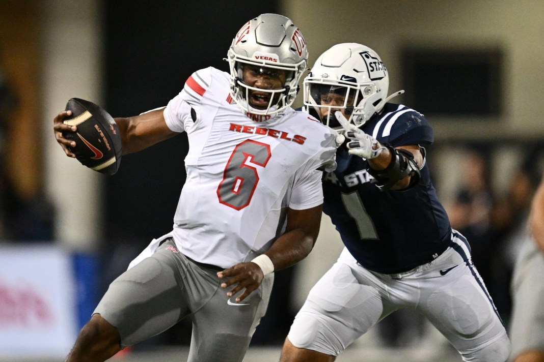 UNLV Rebels quarterback Hajj-Malik Williams (6) scrambles for a first down as Utah State Aggies linebacker Jon Ross Maye (1) makes the tackle