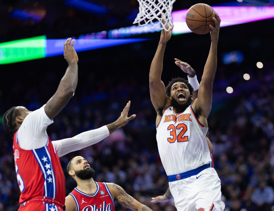 New York Knicks center Karl-Anthony Towns drives for a shot next to Philadelphia 76ers center Andre Drummond