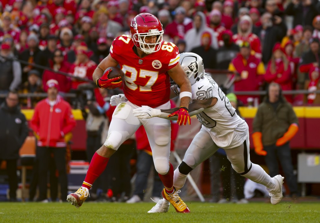 Kansas City Chiefs tight end Travis Kelce (87) runs with the ball against Las Vegas Raiders safety Isaiah Pola-Mao (20)