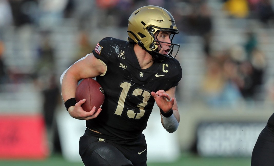 Army Black Knights quarterback Bryson Daily (13) carries the ball on an option run behind Army Black Knights offensive lineman Connor Finucane