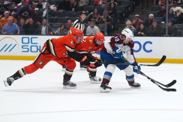 Colorado Avalanche defenseman Samuel Girard skates with the puck against Anaheim Ducks defenseman Radko Gudas