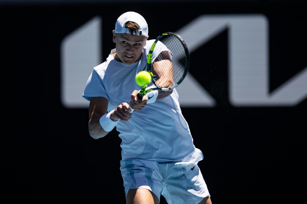 Holger Rune hits a backhand against Zhizhen Zhang at the 2025 Australian Open.