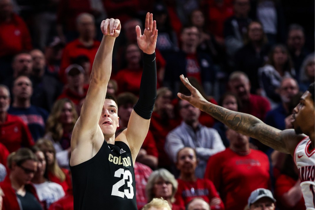 Colorado Buffaloes forward Andrej Jakimovski (23) attempts a three-point shot while Arizona Wildcats guard Caleb Love (1) defends during the first half at McKale Center on January 25, 2025