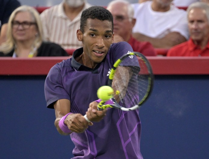 Felix Auger Aliassime hits a backhand against Flavio Cobolli in Montreal in 2024.