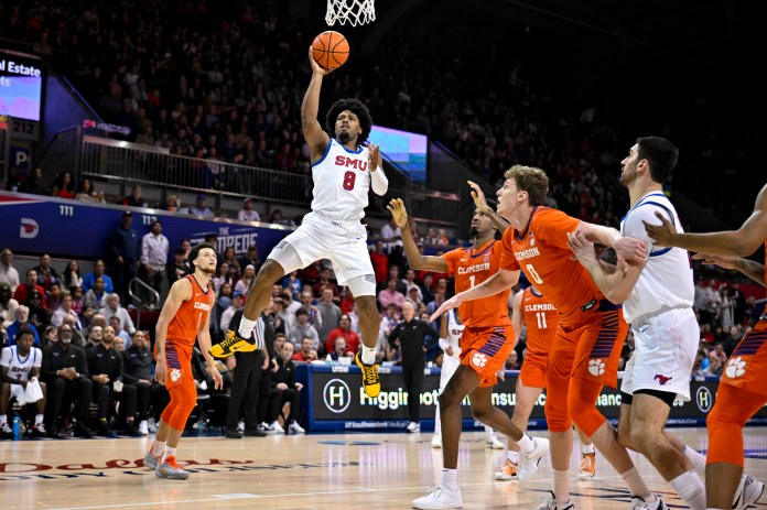 SMU Mustangs guard Kario Oquendo (8) shoots the ball as Clemson Tigers forward Chauncey Wiggins (7) and center Viktor Lakhin (0) look on during the second half at Moody Coliseum on February 22, 2025.