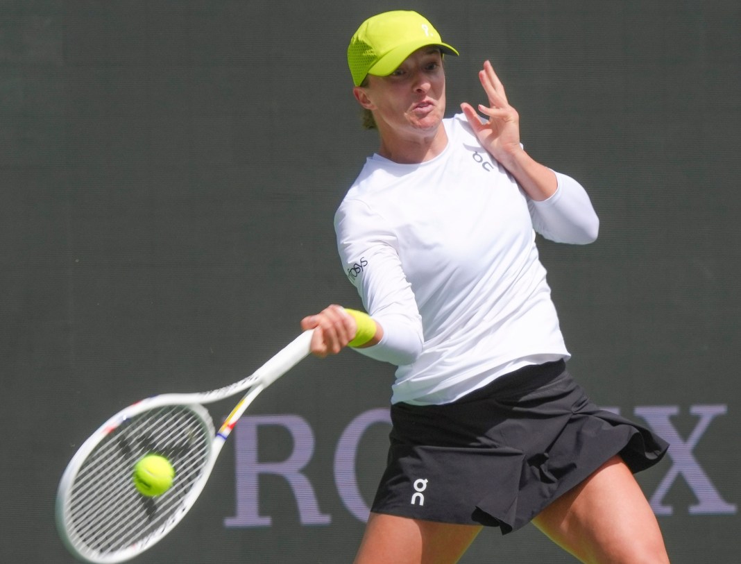 Iga Swiatek hits a forehand against Qinwen Zheng at the 2025 BNP Paribas Open in Indian Wells.