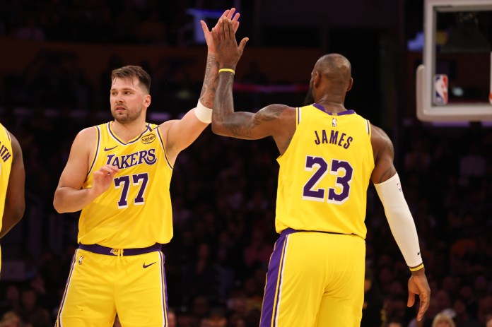 Lakers superstars Luka Doncic and LeBron James high five during a meeting with the Timberwolves in the 2024-25 NBA season.