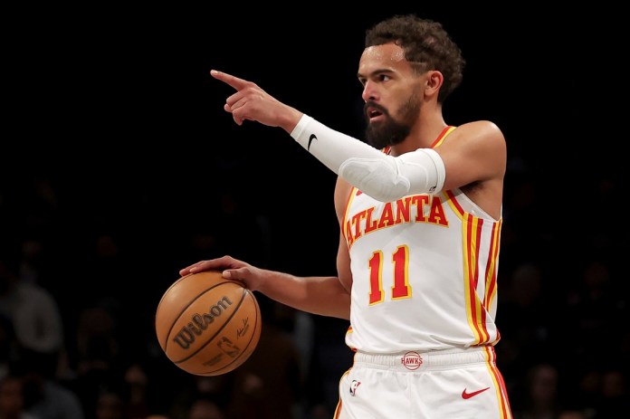 Hawks star Trae Young points against the Nets during the 2024-25 NBA season.