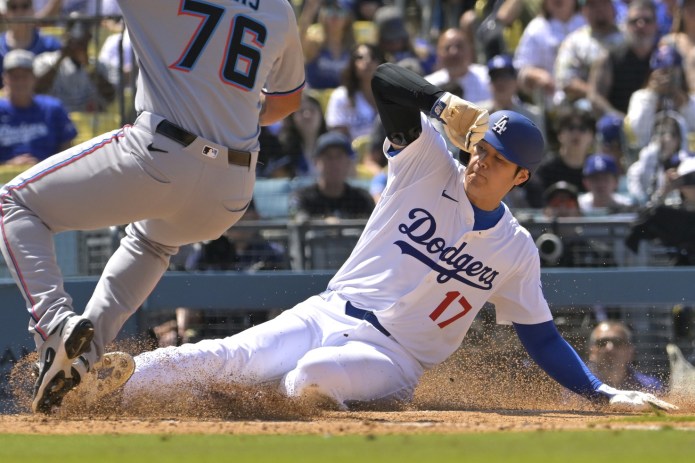 Los Angeles Dodgers designated hitter Shohei Ohtani (17) beats the tag by Miami Marlins relief pitcher Luarbert Arias (76) to score on a wild pitch during the eighth inning at Dodger Stadium in Los Angeles, California, on April 30, 2025.