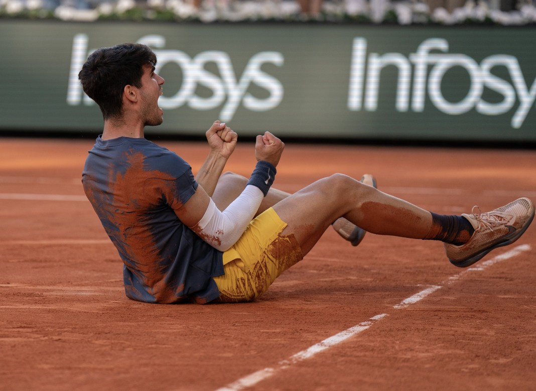 Carlos Alcaraz celebrates defeating Alexander Zverev and winning the 2024 French Open at Roland Garros.