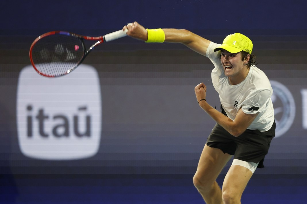 Joao Fonseca serves against Alex de Minaur at the 2025 Miami Open.