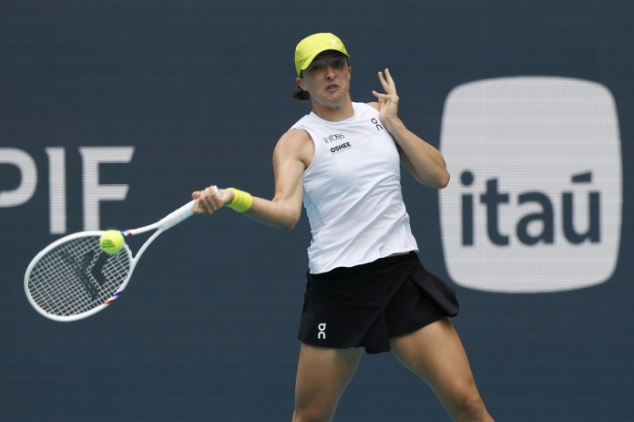 Iga Swiatek hits a forehand in a match at the 2025 Miami Open.