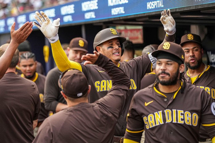San Diego Padres third baseman Manny Machado (13) reacts with teammates in the dugout after hitting a home run during the eighth inning of the game against the Atlanta Braves at Truist Park in Cumberland, Georgia, on May 25, 2025.