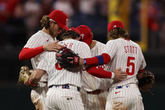 Philadelphia Phillies first baseman Bryce Harper (3), third baseman Alec Bohm (28), second baseman Bryson Stott (5), and shortstop Trea Turner (7) huddle after a victory against the Arizona Diamondbacks at Citizens Bank Park in Philadelphia, Pennsylvania, on May 3, 2025.