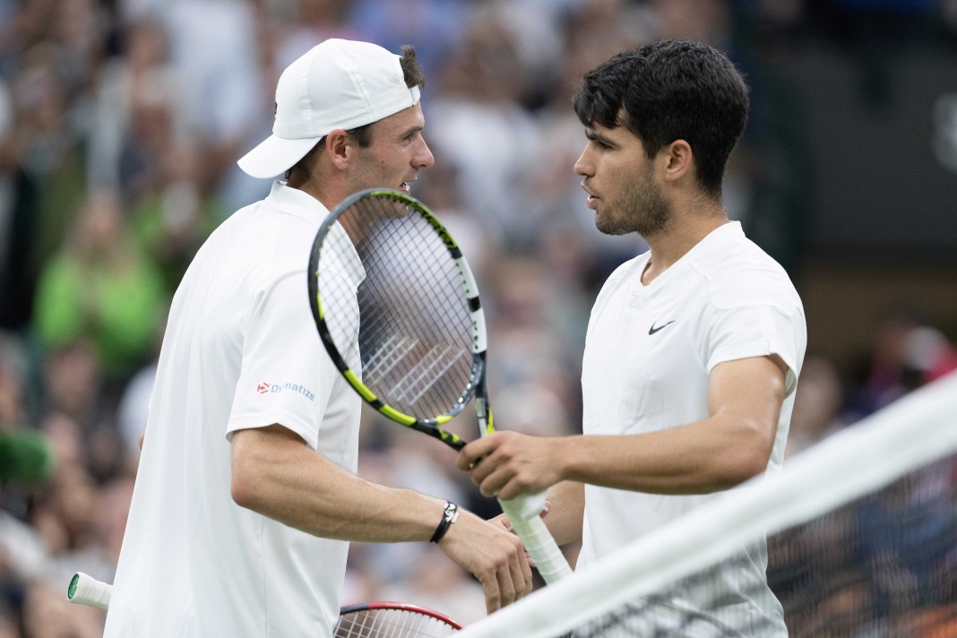 Tommy Paul and Carlos Alcaraz meet at the net at Wimbledon in 2025.