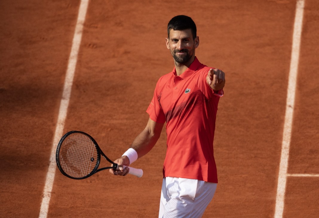 Novak Djokovic points to the crowd after beating Cameron Norrie in the fourth round of the 2025 French Open at Roland Garros.
