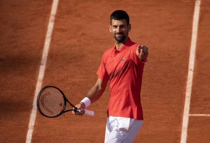Novak Djokovic points to the crowd after beating Cameron Norrie in the fourth round of the 2025 French Open at Roland Garros.