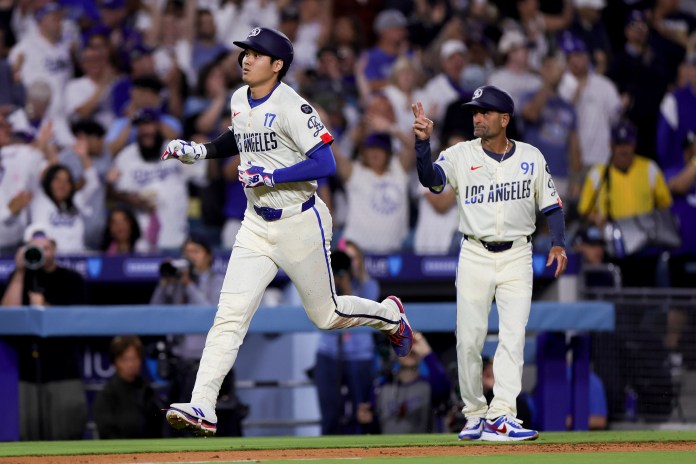 Los Angeles Dodgers designated hitter Shohei Ohtani (left) celebrates with third base coach Dino Ebel after hitting a solo home run during the sixth inning against the San Francisco Giants at Dodger Stadium in Los Angeles, California, on June 14, 2025.