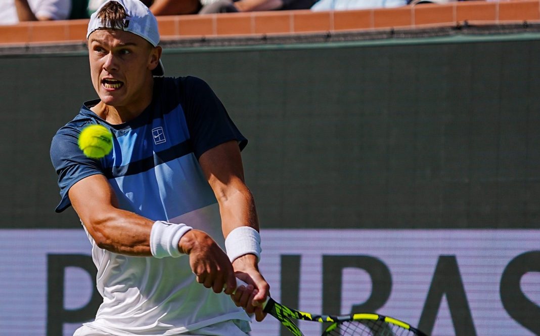 Holger Rune hits a backhand in a match against Jack Draper in the 2025 BNP Paribas Open final in Indian Wells.