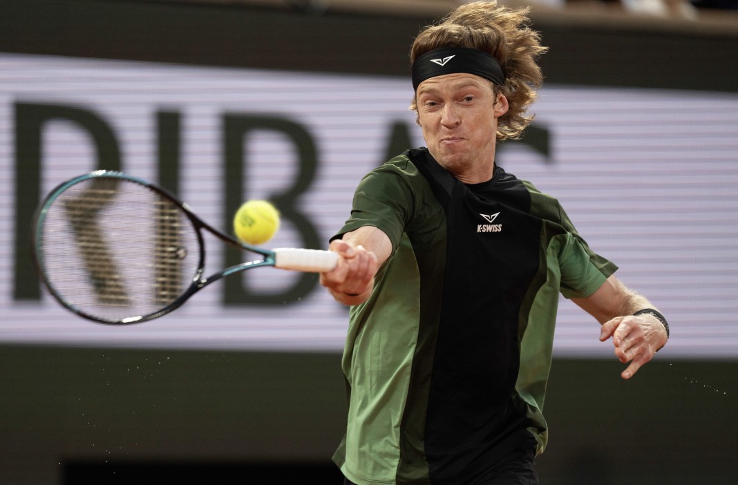Andrey Rublev hits a forehand against Jannik Sinner at the 2025 French Open at Roland Garros.
