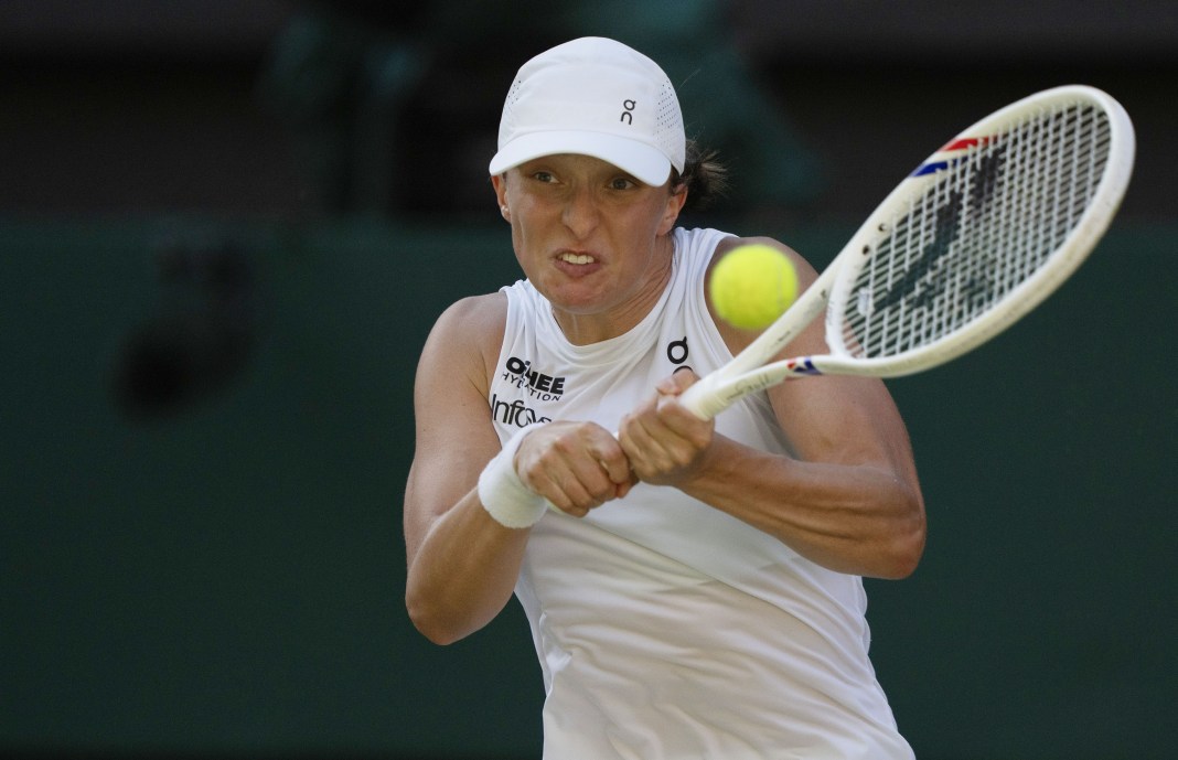 Iga Swiatek hits a backhand against Belinda Bencic in the 2025 Wimbledon semifinals.