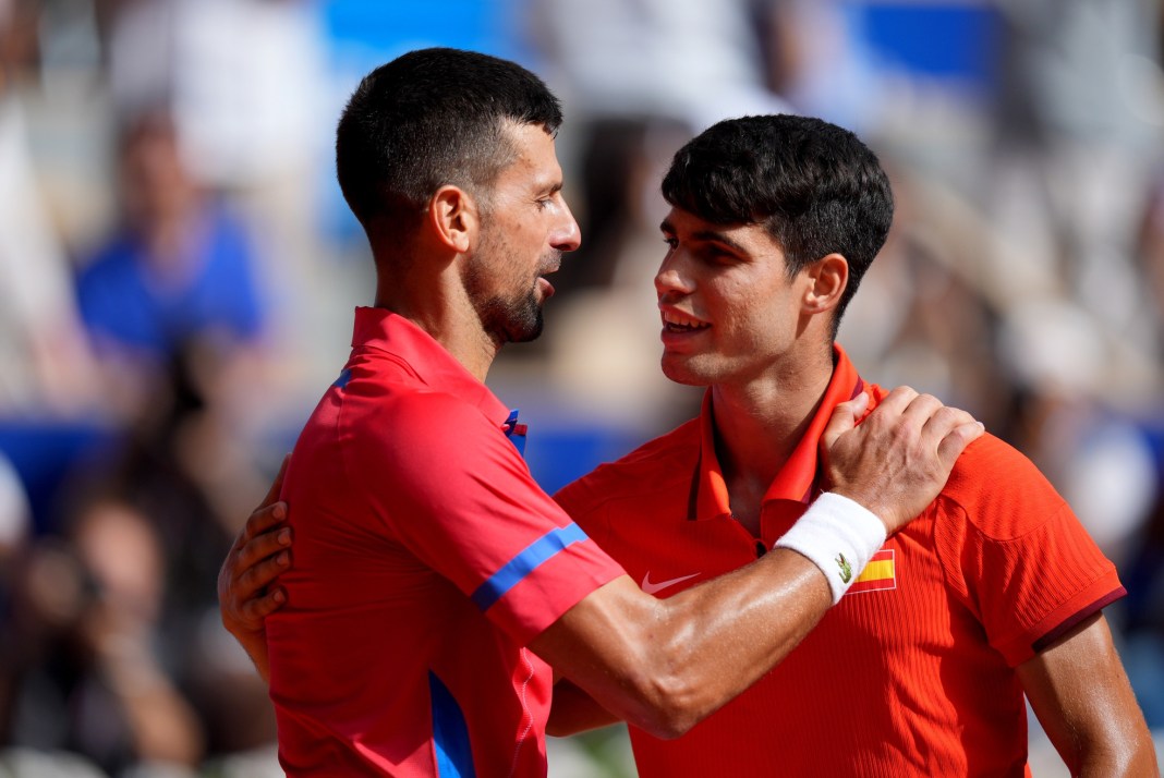 Novak Djokovic and Carlos Alcaraz meet at the net after the gold medal match at the 2024 Paris Olympics.