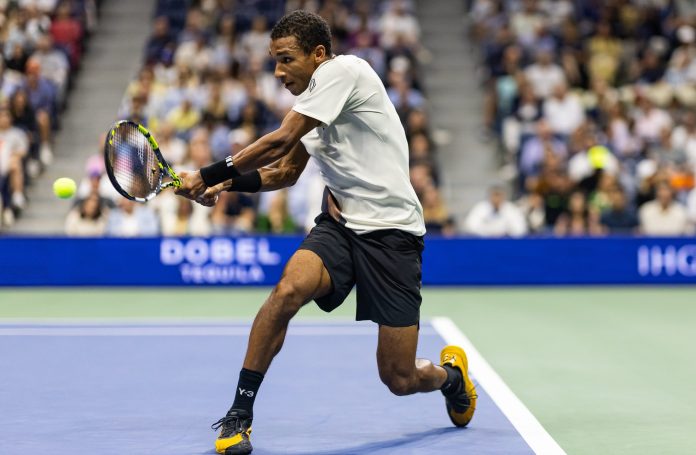 Felix Auger Aliassime hits a backhand against Jannik Sinner at the 2025 US Open.