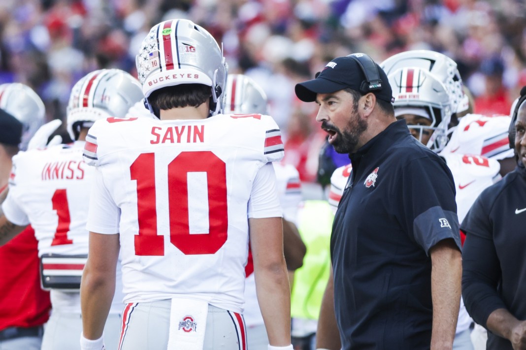 Ohio State head coach Ryan Day talks to quarterback Julian Sayin in a meeting with Washington in the 2025 college football season.