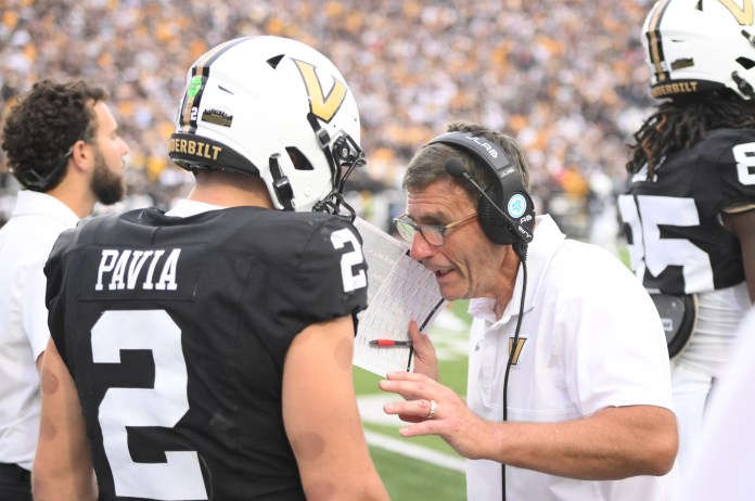 Vanderbilt quarterback Diego Pavia talks to his assistant coach during a game against Missouri in the 2025 college football season.