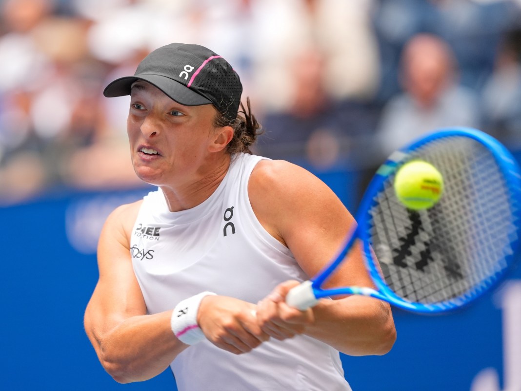 Iga Swiatek hits a backhand in a match against Suzan Lamens at the 2025 US Open.