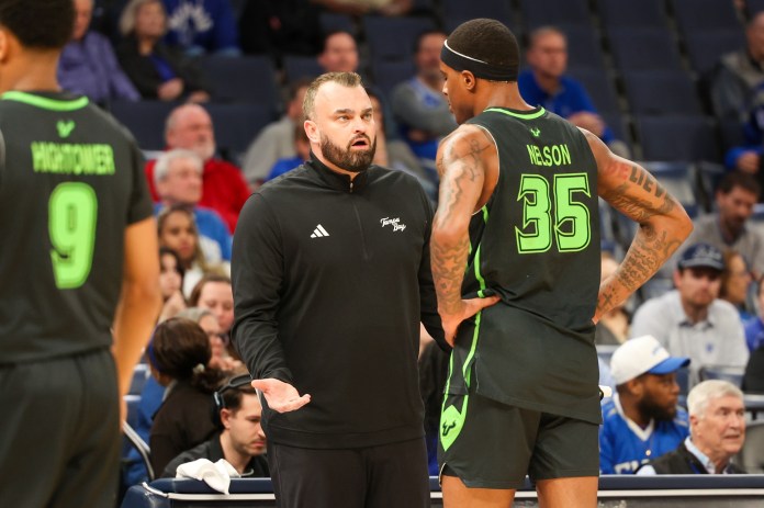 South Florida coach Bryan Hodgson talks to Izaiyah Nelson during the 2025-26 college basketball season.
