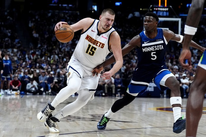 Nuggets superstar Nikola Jokic drives on Timberwolves superstar Anthony Edwards.