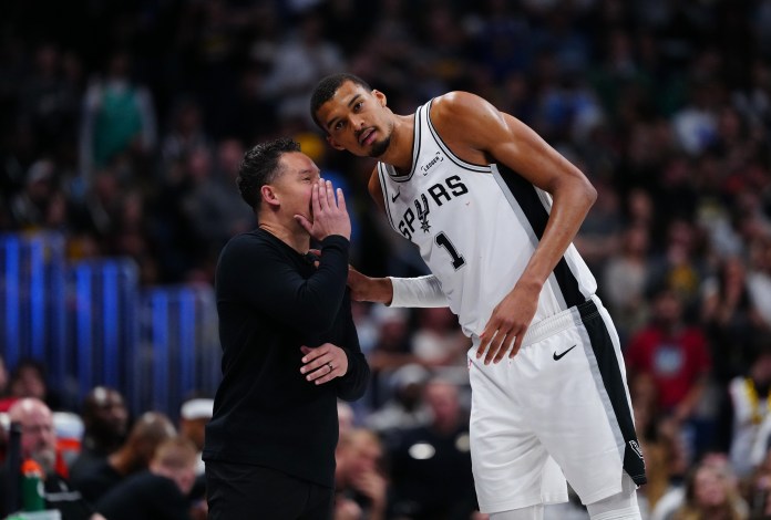 Spurs superstar Victor Wembanyama talks to head coach Mitch Johnson during the 2025-26 NBA season.