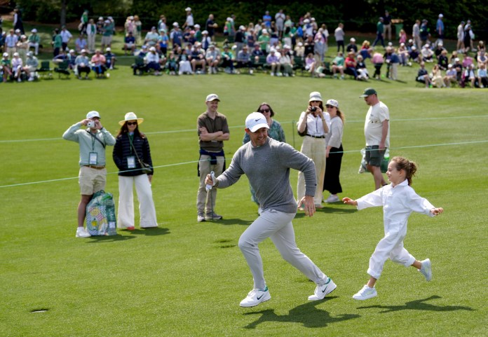 Rory McIlroy runs down the third fairway with his daughter, Poppy.
