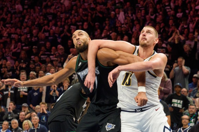 Timberwolves center Rudy Gobert and Nuggets star Nikola Jokic fight for the ball in the 2025-26 NBA Playoffs.