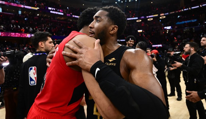 Cavaliers guard Donovan Mitchell (45) hugs Toronto Raptors forward Scottie Barnes.