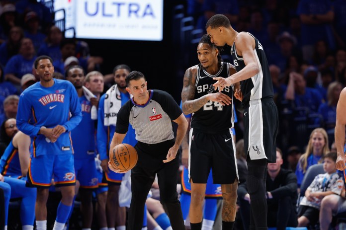 Spurs star Victor Wembanyama embraces Devin Vassell during Game 1 against the Thunder in the 2025-26 NBA Playoffs.